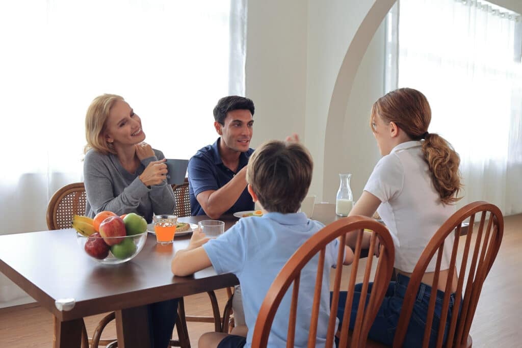 Familia compartiendo un momento fuerte en la cena. Todos sentados en la mesa. Felices.