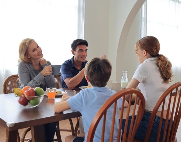 Familia compartiendo un momento fuerte en la cena. Todos sentados en la mesa. Felices.